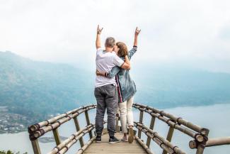 Image of a couple on a bridge overlooking water
